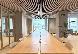 een lange houten vergadertafel in een kantoor met stoelen bij aparto Diagonal Suites in Esplugues de Llobregat +40 foto's