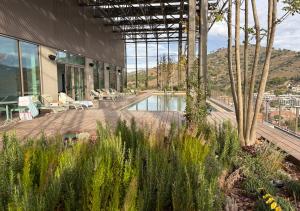een gebouw met een zwembad, stoelen en bomen bij aparto Diagonal Suites in Esplugues de Llobregat
