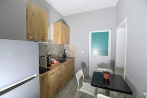 a kitchen with a table and a refrigerator at N'Baz Apartment - Pedonale, Shkodër in Shkodër