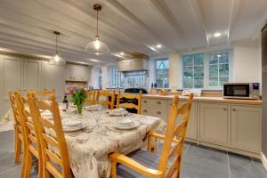 een eetkamer met een tafel en stoelen en een keuken bij 4 Bed in Looe oc-p00795 in Lansallos