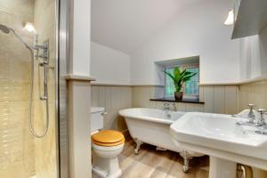 een badkamer met een bad, een toilet en een wastafel bij 4 Bed in Looe oc-p00795 in Lansallos +19 foto's