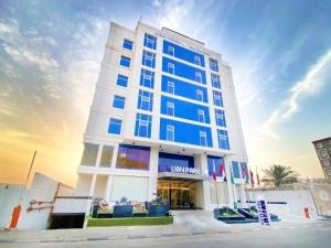 a tall building with blue windows on a street at فندق ليان بارك Lian Park Hotel in Al Khobar