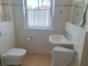 un bagno bianco con un water e un lavandino di Sonniges Zimmer im Einfamilienhaus a Niederdorla