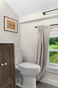 a bathroom with a toilet and a window at NEW HOT TUB Game Room Firepit Near Windham in Prattsville +43 photos