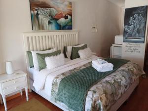 a bedroom with a large bed with green and white pillows at Cosy Stay in Robertson