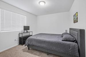 een witte slaapkamer met een bed en een raam bij Modern 2BR 2BA Townhome 15 Min to DEN in Commerce City +16 foto's
