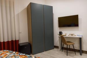 a bedroom with a desk and a cabinet with a tv at B&B Bifulco Boutique Rooms in Ottaviano
