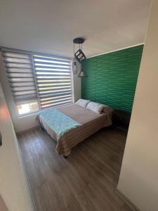 een slaapkamer met groene luiken en een bed bij Estacionamiento, Céntrico y Cómodo in Chillán