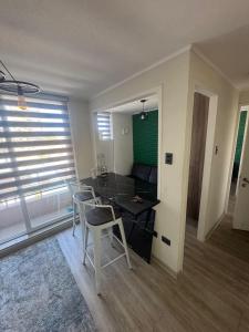 een woonkamer met een tafel, stoelen en een bank bij Estacionamiento, Céntrico y Cómodo in Chillán