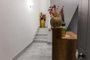 a hallway with a stairway with vases and a door at B&B Bifulco Boutique Rooms in Ottaviano