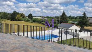 a view of a swimming pool behind a fence at Villa Manosque in Les Ponts-de-Cé