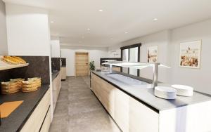 una cucina con armadietti bianchi e bancone di Hostel Maria Alm a Maria Alm am Steinernen Meer Altre 4 foto