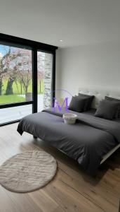 a bedroom with two beds and a large window at Villa Manosque in Les Ponts-de-Cé