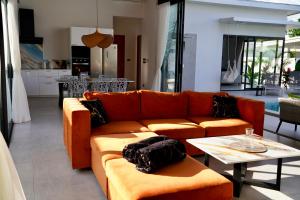 a living room with an orange couch and a table at Villa Mona in Nathon Bay