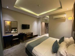 a hotel room with a bed and a desk and a television at فندق ليان بارك Lian Park Hotel in Al Khobar