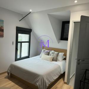 a bedroom with a bed with white sheets and a window at Villa Manosque in Les Ponts-de-Cé