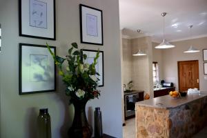 a kitchen with a vase of flowers on the wall at Rawlingsons Country House in Dullstroom +48 photos