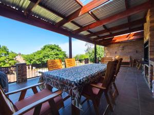 a patio with a table and chairs on a deck at Rawlingsons Country House in Dullstroom