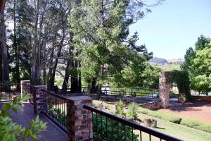 a park with a fence and trees in the background at Rawlingsons Country House in Dullstroom