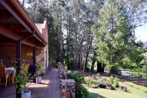 a porch of a house with a table and chairs at Rawlingsons Country House in Dullstroom