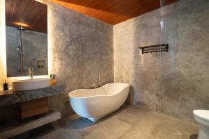 een badkamer met een bad, een wastafel en een toilet bij Villa Taru Jagat in Saba +16 foto's