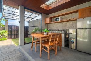 een buitenkeuken met een houten tafel en stoelen bij Villa Taru Jagat in Saba