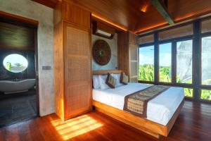 een slaapkamer met een bed en een badkamer met een bad bij Villa Taru Jagat in Saba