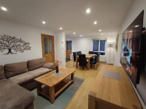 a living room with a couch and a table at 3 bedroom HOUSE, Garden, PARKING, Wi-fi, CONTRACTOR STAY, close to the beach, shops, hospital, airport in Bournemouth