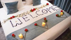 a birthday cake with candles and flowers on a bed at فندق ليان بارك Lian Park Hotel in Al Khobar +76 photos