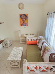 ein Wohnzimmer mit Sofa und Tisch in der Unterkunft Orange apartments in Watamu