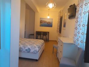 a bedroom with a bed and a desk and a table at Elegant mini appartments Floridia close to the center private parking in Taormina