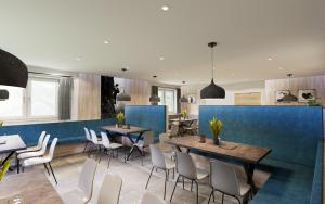 un ristorante con pareti blu, tavoli e sedie di Hostel Maria Alm a Maria Alm am Steinernen Meer