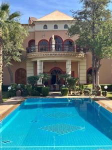 a large house with a swimming pool in front of it at Villa Oum Palace in Marrakesh