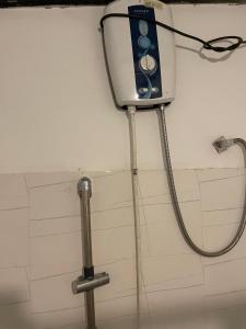 une douche dans une salle de bain avec un tuyau raccordé au mur dans l'établissement Femingo by Costels, à Hiriketiya