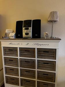 une commode avec une radio et des haut-parleurs dessus dans l'établissement Mühlenblick, à Brunshaupten