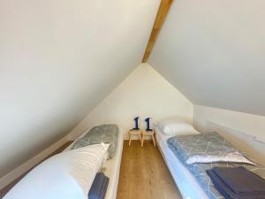 2 Betten in einem Dachzimmer mit einem Tisch in der Unterkunft Kervel - Cocon Breton avec WiFi et Parking in Locronan