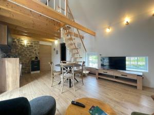 ein Wohnzimmer mit einem Esstisch und einem TV in der Unterkunft Kervel - Cocon Breton avec WiFi et Parking in Locronan