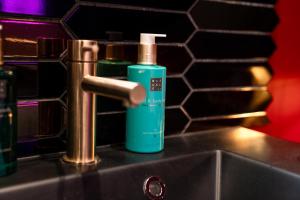 a bathroom sink with a green bottle of mouthwash at Suite Jacuzzi & Sauna privatifs - Paris - Or Norme By Le Douze in Paris