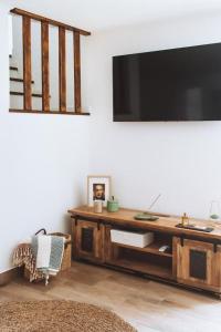 un soggiorno con una grande TV su una parete di Chão do Ribeirinho Country House a Atalaia