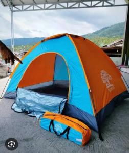 ein orange-blaues Zelt, das auf dem Boden steht in der Unterkunft Giant Tent in Baso