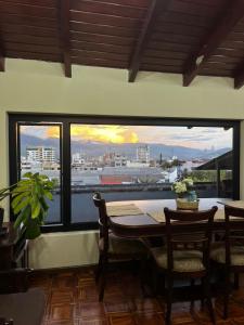 ein Esszimmer mit einem Tisch und Blick auf die Stadt in der Unterkunft Departamento tranquilo con terraza privada in Riobamba