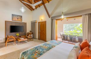 a bedroom with a large bed and a television at The Forest Chapter by Sayaji Madhai in Sohāgpur