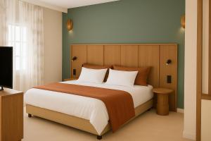 a bedroom with a large bed and a television at Hôtel de l'Horloge in Avignon