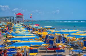 een stel stoelen en parasols op een strand bij Roma By Sea in Lido di Ostia