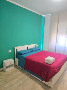 een blauwe slaapkamer met een bed met een rode deken bij Roma By Sea in Lido di Ostia