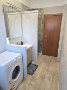 een wasruimte met een wasmachine en een spiegel bij Roma By Sea in Lido di Ostia