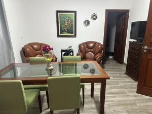 a dining room with a table and leather chairs at Micaelense Guest House in Ponta Delgada