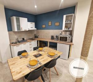 a kitchen with a wooden table and chairs in a kitchen at Atypique Souplex Hyper centre Ecusson - Clim - 4p in Nîmes