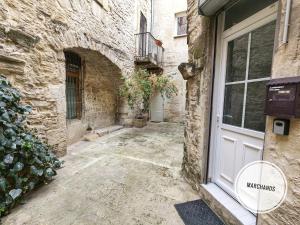 eine steinerne Gasse mit einer Tür in einem Gebäude in der Unterkunft Atypique Souplex Hyper centre Ecusson - Clim - 4p in Nîmes