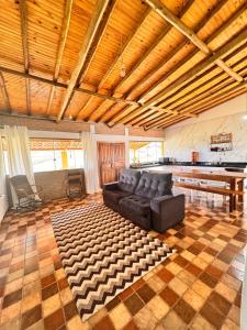 ein Wohnzimmer mit Sofa und Tisch in der Unterkunft Sítio Vista da Serra - Carrancas in Carrancas